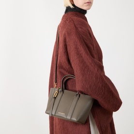 Model carrying Marc Jacobs The Small Work Tote Bag in Forest pebbled leather, gold-tone hardware, dual top handles and crossbody strap