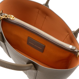 Marc Jacobs Forest tote bag interior showing orange lining, gold-tone zip pocket, and khaki leather exterior with dual handles.