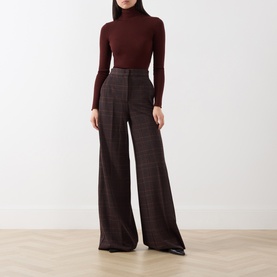 Model wearing Max Mara Main brown wool turtleneck top, styled with wide-leg checked trousers and black shoes.
