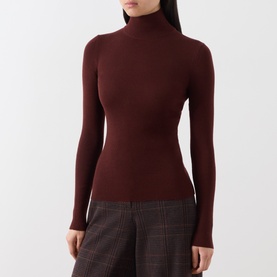 Model wearing Max Mara Main brown wool ribbed turtleneck top, styled with grey check wide-leg trousers