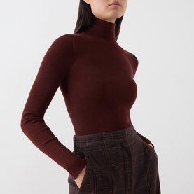 Model wearing Max Mara Main brown wool turtleneck top, styled with grey check wide-leg trousers