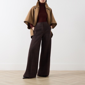 Model wearing Max Mara Main brown wool turtleneck top, styled with camel cape and wide-leg brown trousers.