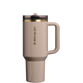 Stanley tumbler in Bedrock Gloss finish with gold-tone lid hardware, handle, and branded logo detail, shown on white background.