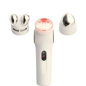 Theragun facial device in white with three interchangeable heads, including red light therapy and dual-sphere attachments, LED display panel