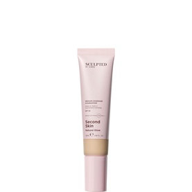 Sculpted by Aimee Second Skin Natural Glow Foundation in a pink tube with warm-toned shade visible at nozzle tip