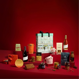 Brown Thomas Food Retail Hamper with assorted wines, biscuits, preserves, chocolates and snacks displayed on red background