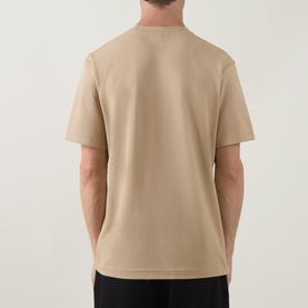 Model wearing Lacoste beige crew neck T-shirt, back view, short sleeves, 100% cotton plain jersey fabric.