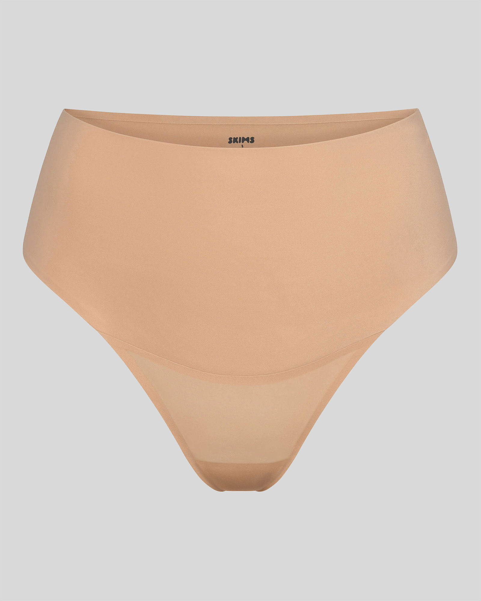 Beige high-waisted underwear on a neutral background.