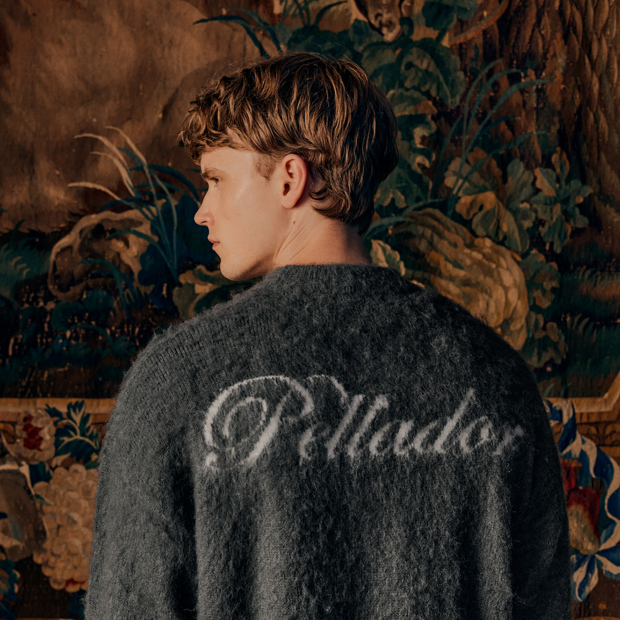 Menswear model in textured knit Pellador jumper with script logo on the back