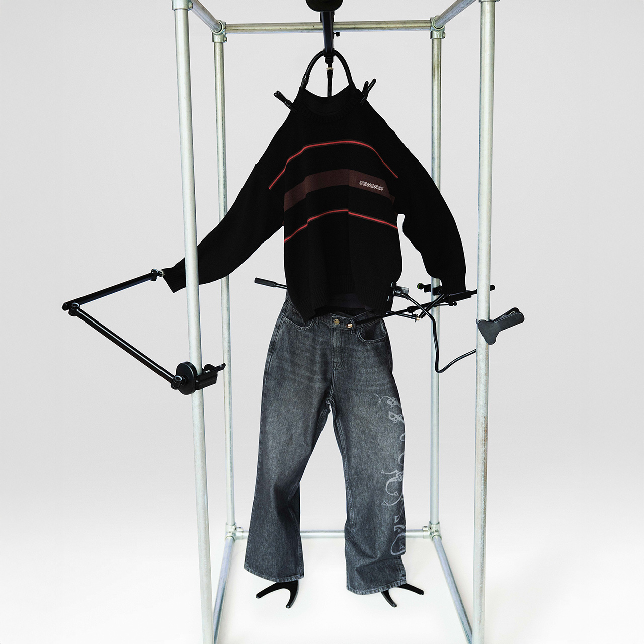 Robyn Lynch jumper and jeans displayed in a steel frame