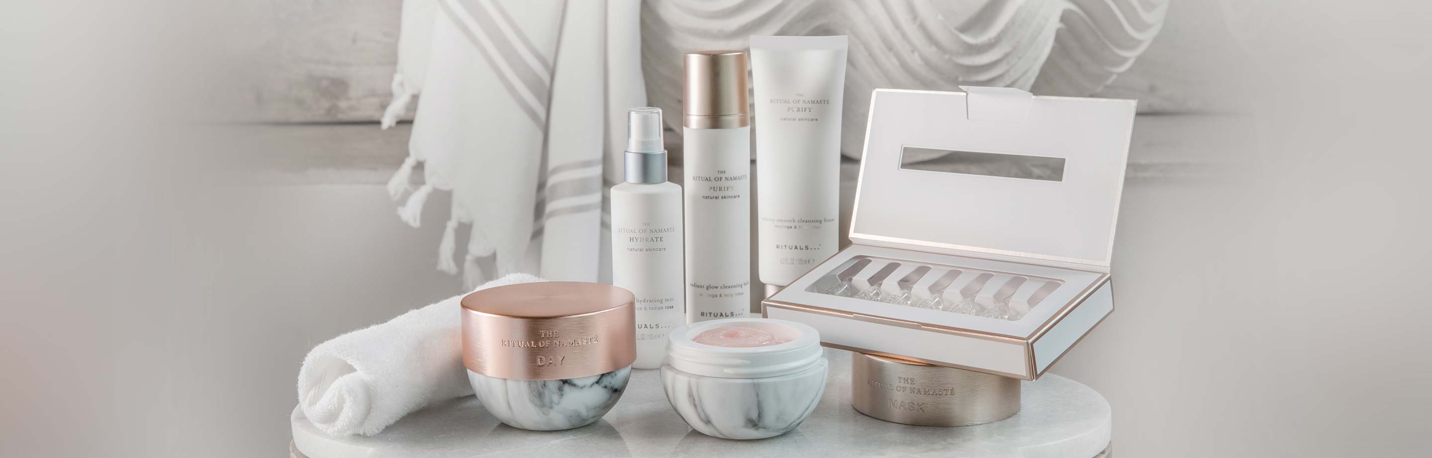 A collection of skincare products and towels, evoking a luxurious ritual setting.