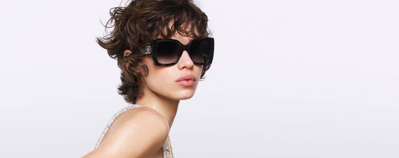 Person with short hair wearing large Chanel sunglasses.