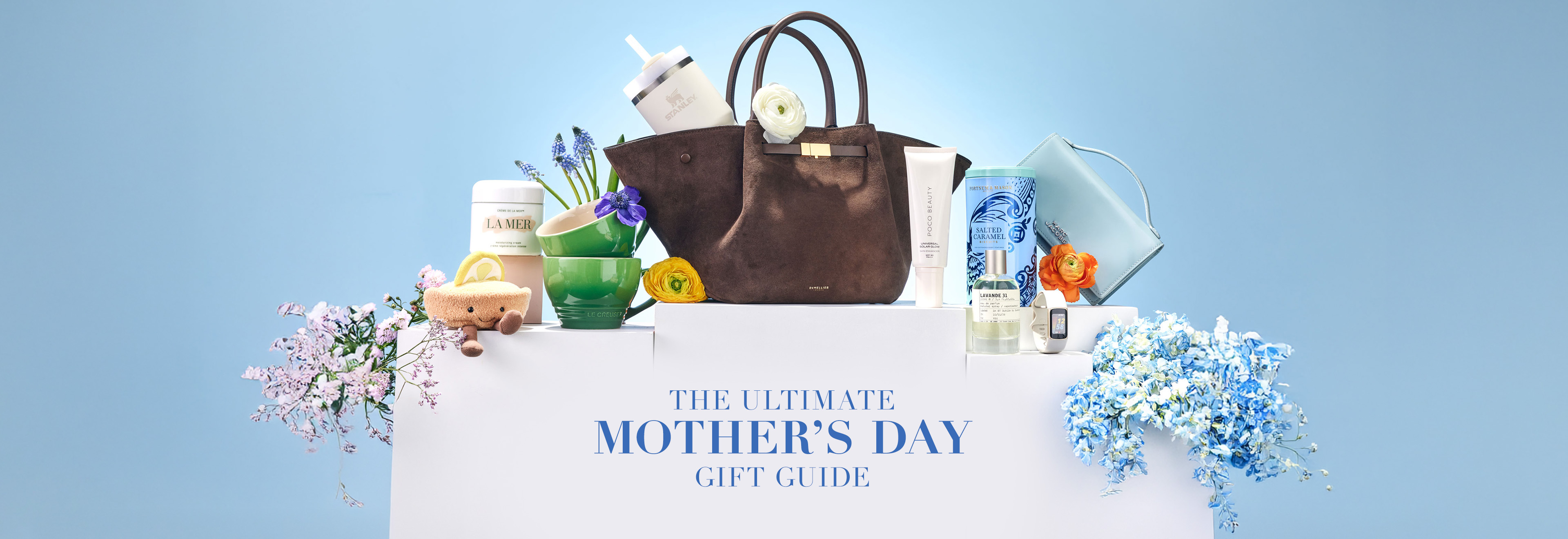 Mother's Day gift guide display with various gift items, including a handbag, flowers, and beauty products against a blue background.