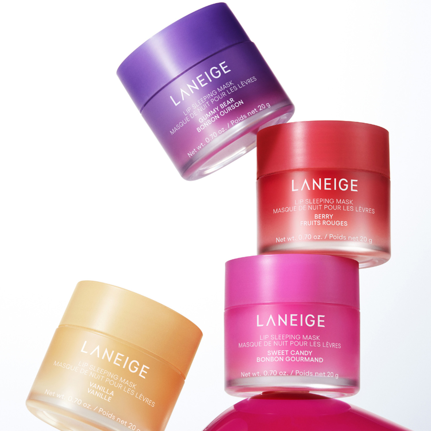 Four LANEIGE Lip Sleeping Mask jars in purple, red, orange, and pink, stacked and floating against a white background.