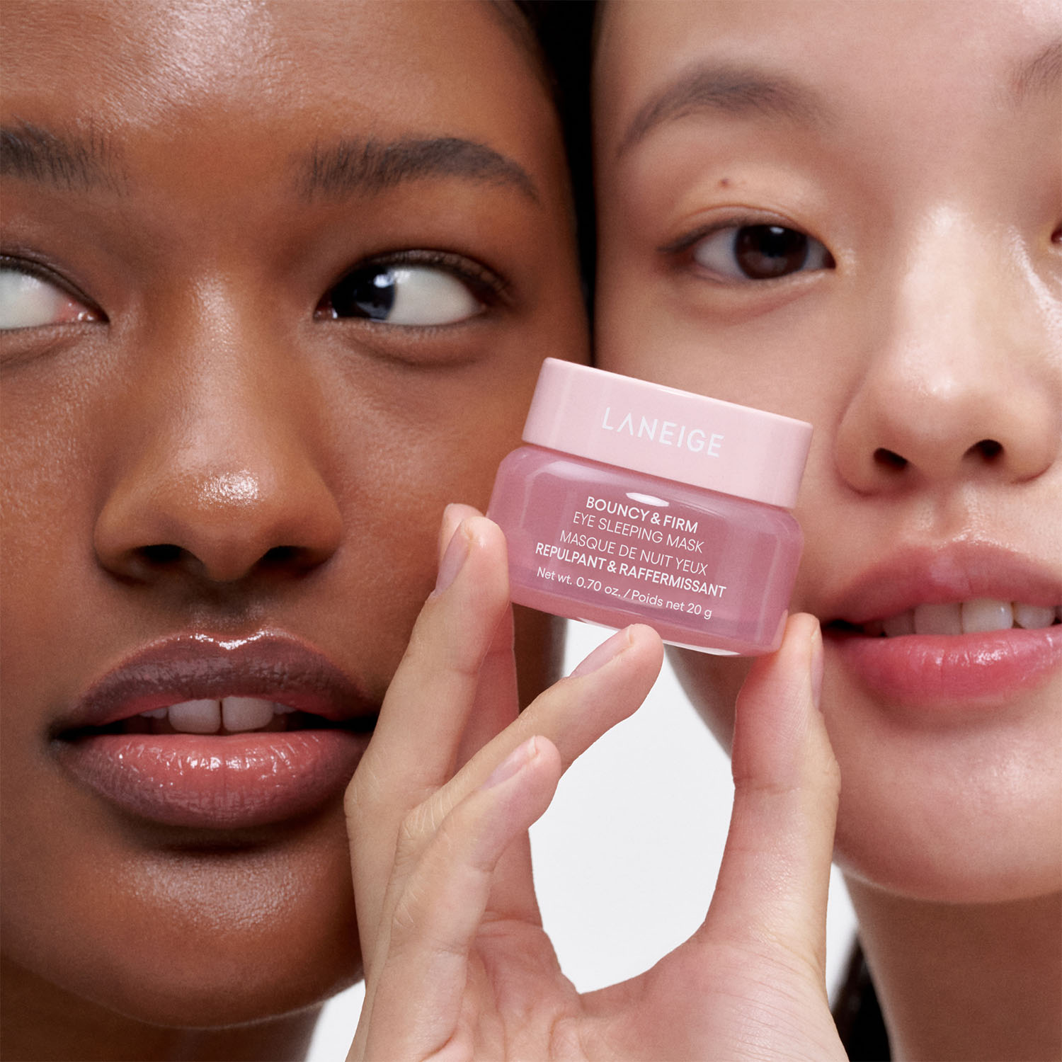 Two people with clear skin pose closely, holding a Laneige eye sleeping mask jar.