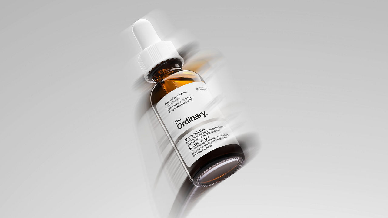 Bottles of The Ordinary skincare products are arranged around the text 'The Ordinary Squalane' on a gray background.