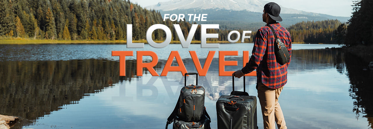 Man standing at a scenic lake with Samsonite luggage