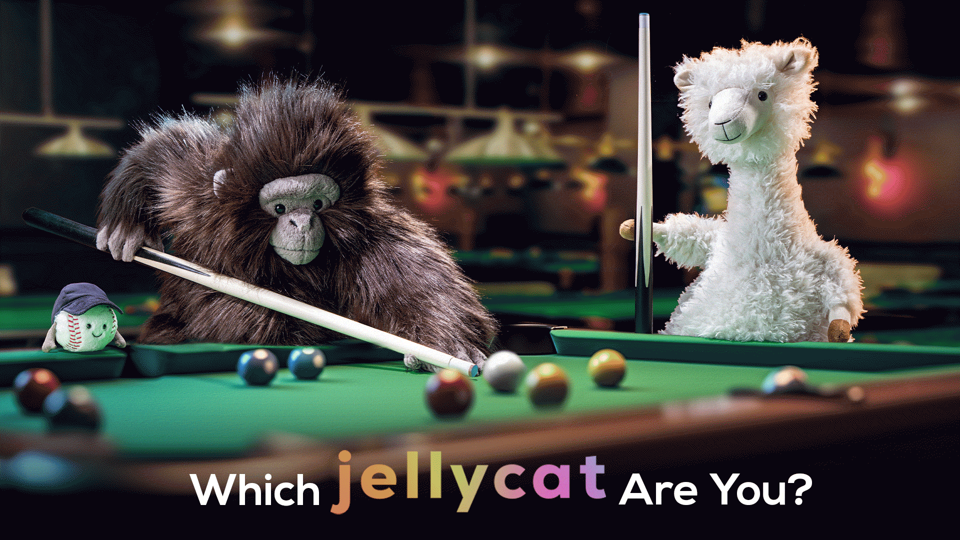 Plush toys, including a gorilla and llama, play pool with the text 'Which Jellycat Are You?'